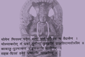 Eine Patanjali-Statue mit dem Sanskrit-Text der Ode an Patanjali auf violettem Hintergrund